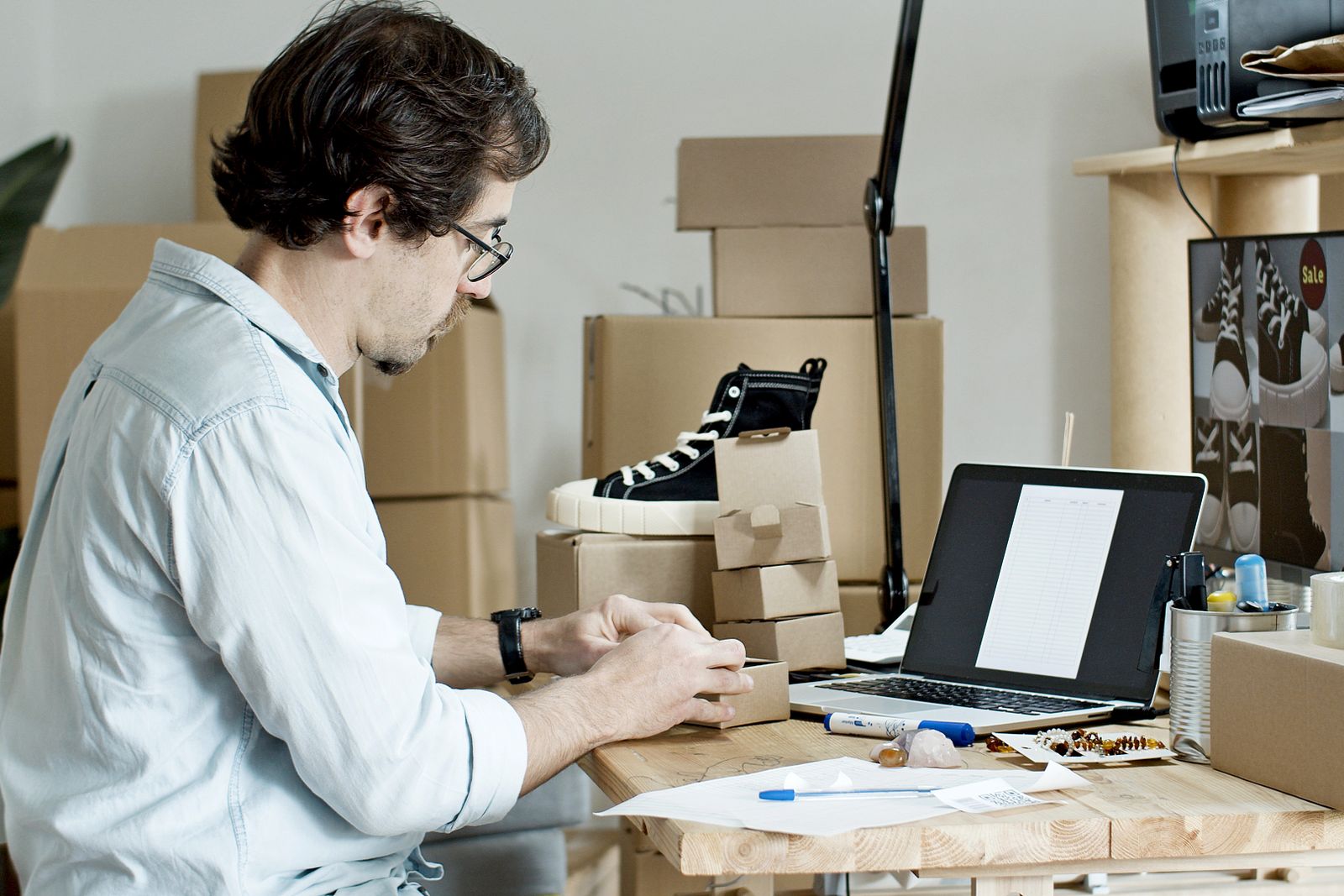 Small business owner preparing online orders at a laptop workspace